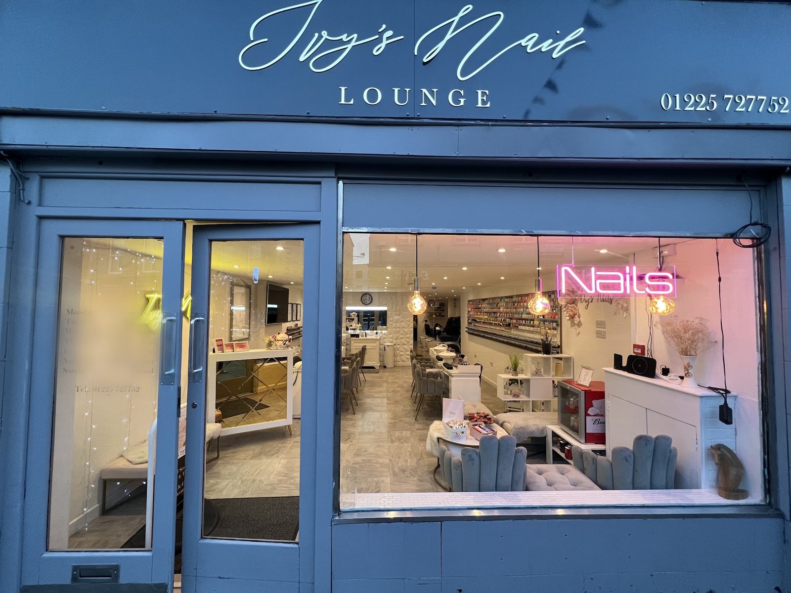 The Ivy’s Nail Lounge shopfront on Melksham High Street, with its slate-blue fascia and a neon Nails sign in the window