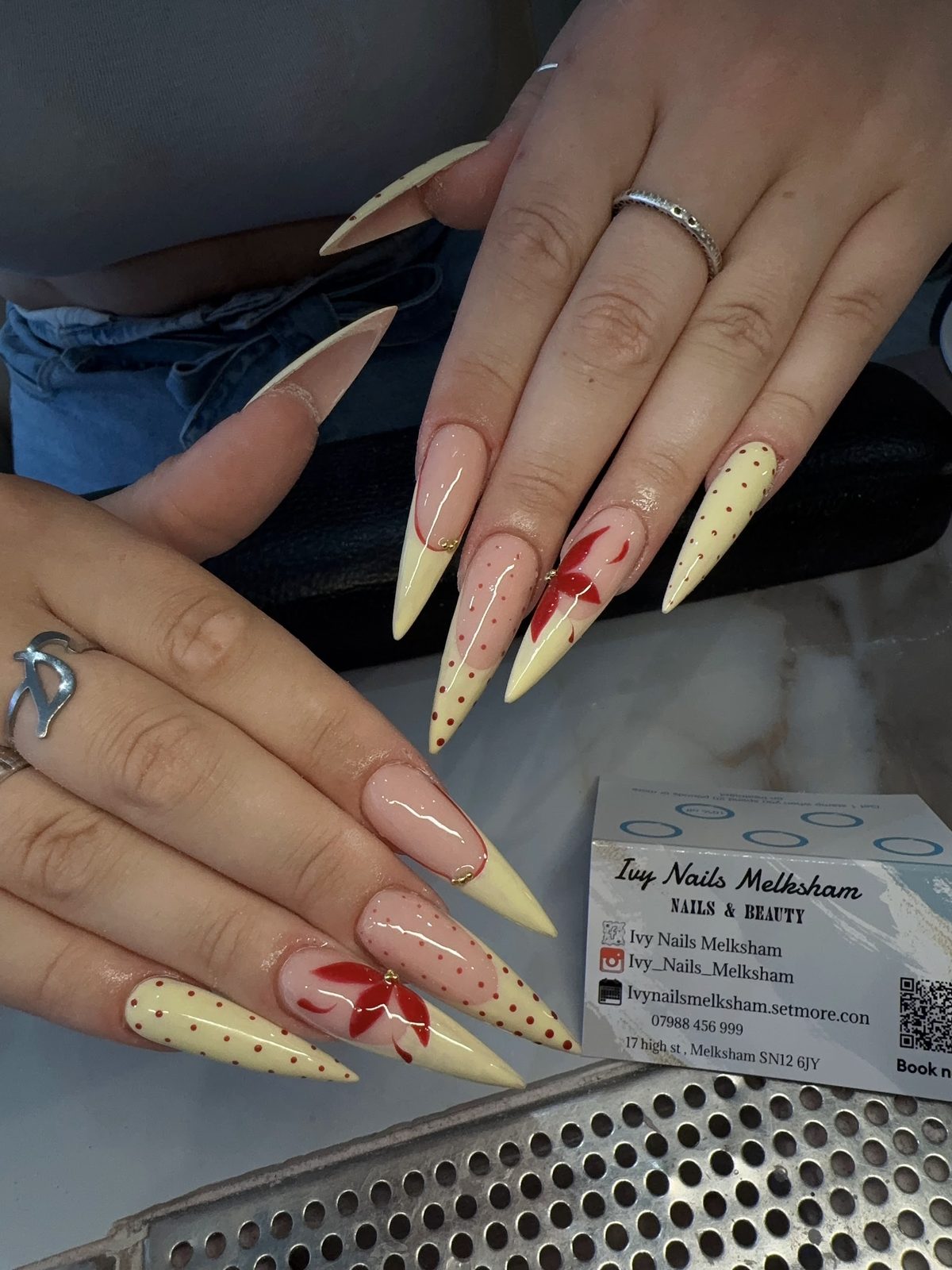 Long pale yellow stilettos with a red flower and polka-dot art