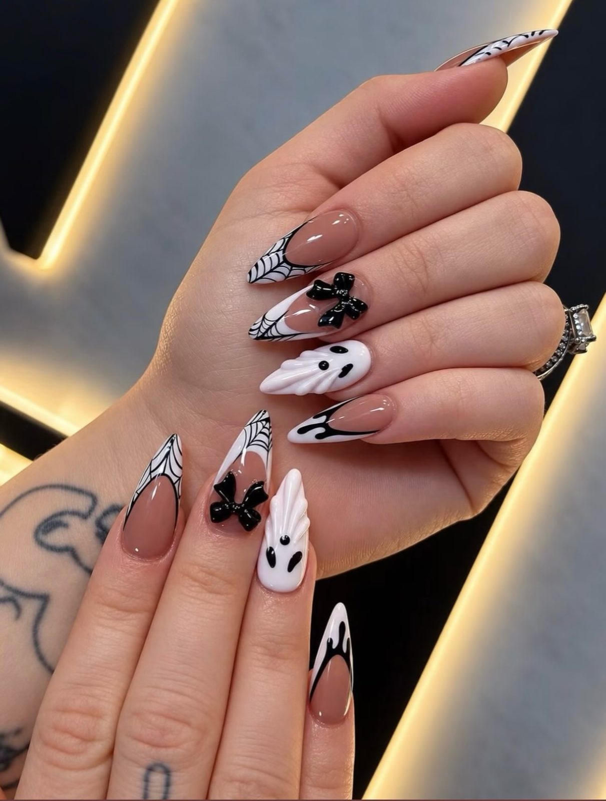 Almond nude nails with black and white ghosts, webs and bows